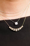 On figure 14K yellow gold amorati diamonds emery emerald cut necklace layered with Lumin Cushion Diamond Pendant Necklace.