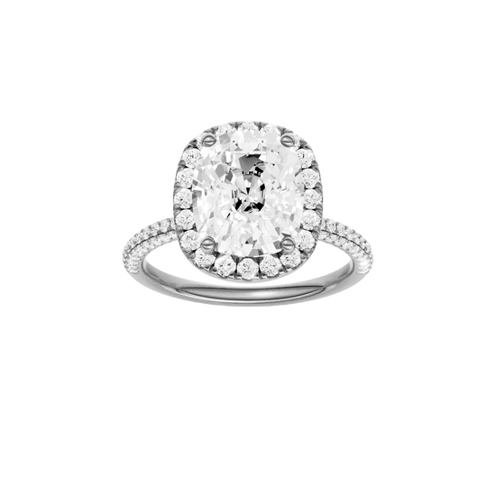 Elongated cushion-cut diamond engagement ring with a pavé-set diamond band and halo setting.