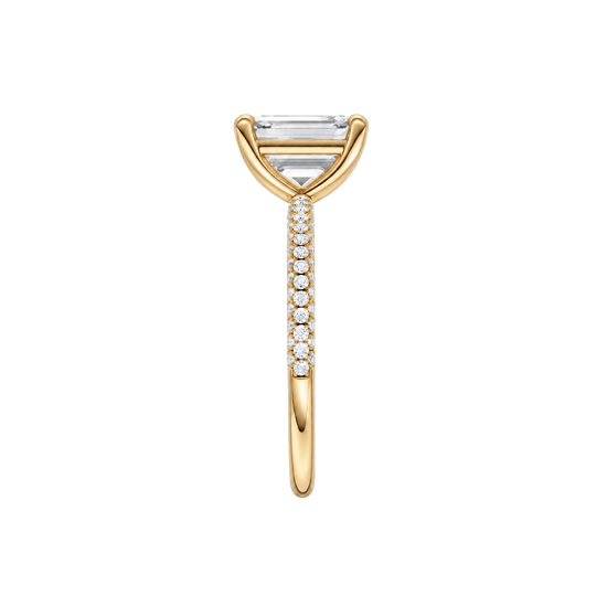 A side view of the Emerald cut diamond engagement ring in 14k yellow gold with a prong diamond band and cathedral setting
