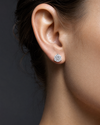 Profile view of a woman's ear wearing a round diamond stud earring.