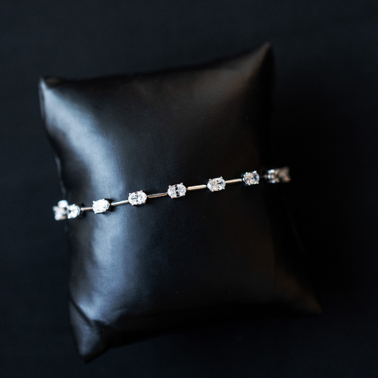 White gold Amorati eternal diamond strand bracelet displayed on a black jewelry cushion.