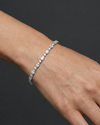 White gold oval diamond tennis bracelet worn on the wrist, draping naturally and offering elegant sparkle with a refined silhouette.