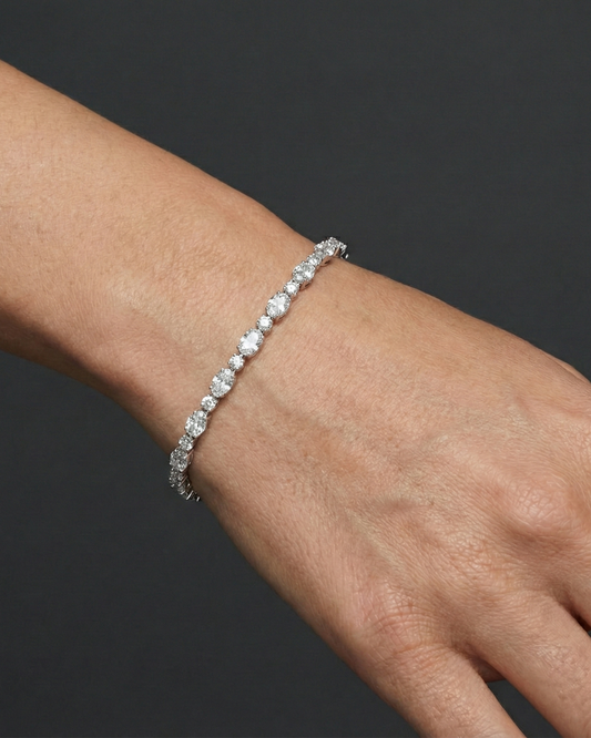 White gold oval diamond tennis bracelet worn on the wrist, draping naturally and offering elegant sparkle with a refined silhouette.