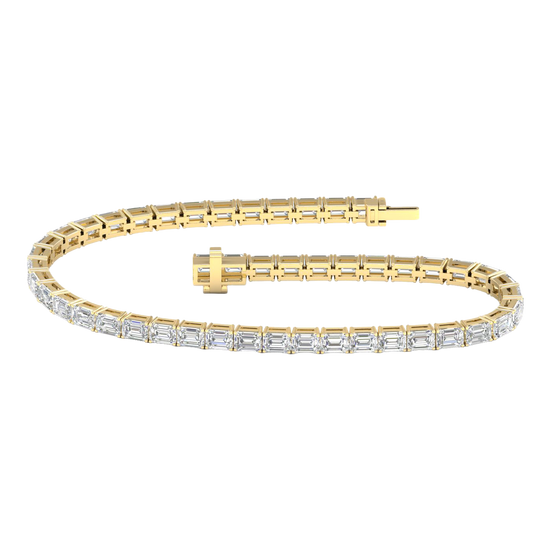 Wide view of a yellow gold diamond tennis bracelet featuring emerald cut white diamonds set in a continuous line, showcasing the full bracelet design.