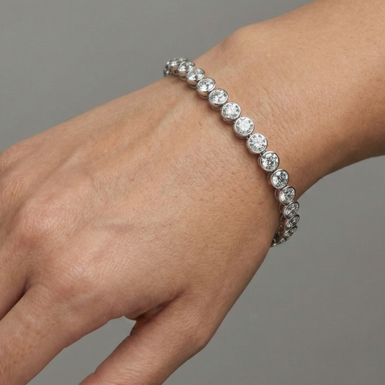 A full top-down view of a 14K white gold tennis bracelet, coiled to show the seamless circle of brilliant diamonds on wrist.