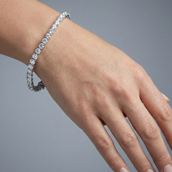 An angled view of the 14K white gold F VS diamond tennis bracelet, showing the gold cup setting and secure clasp on wrist.