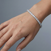 A full top-down view of a 14K white gold bracelet, coiled to show the continuous V-shaped pattern of marquise diamonds on wrist