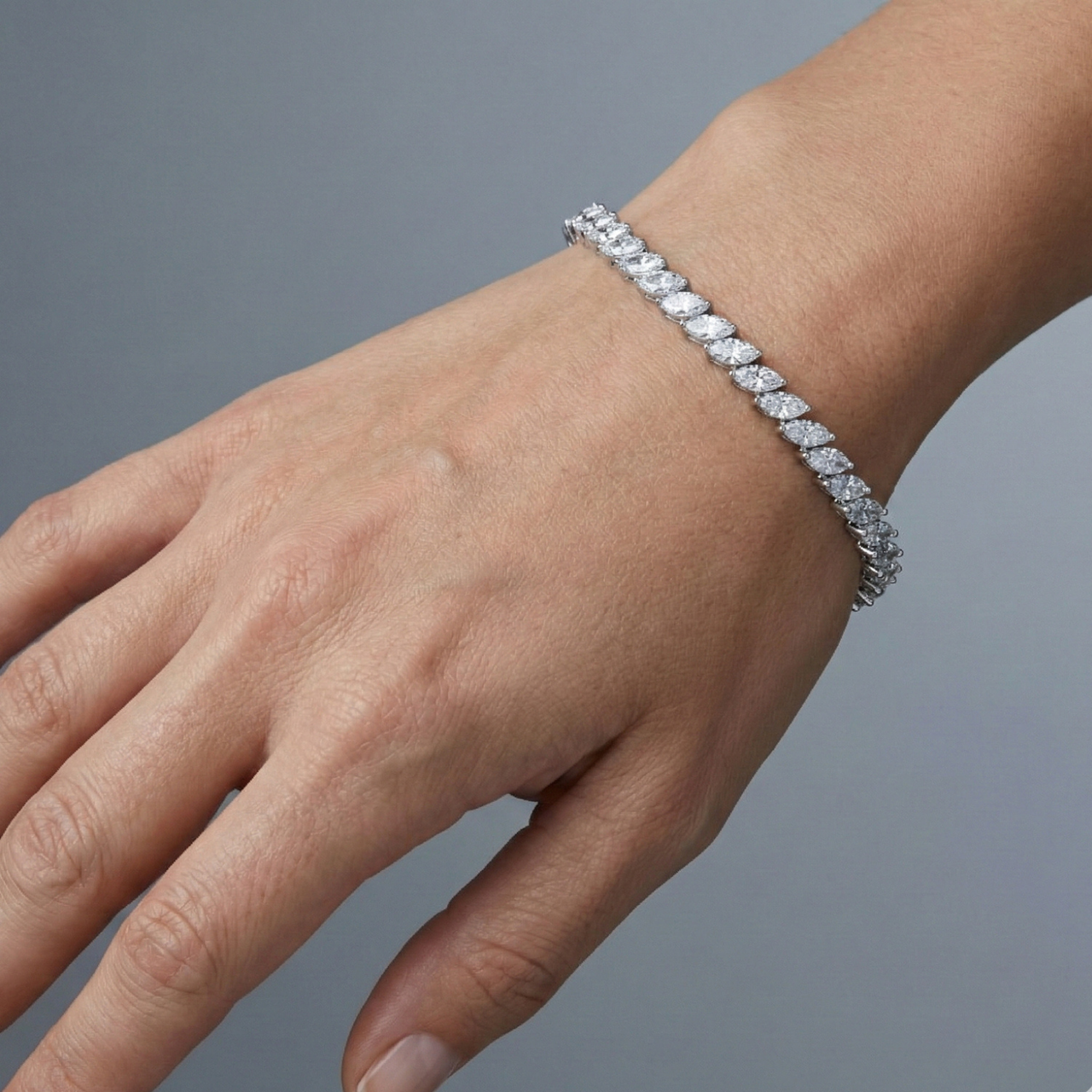 A full top-down view of a 14K white gold bracelet, coiled to show the continuous V-shaped pattern of marquise diamonds on wrist