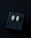 White gold Amorati Enchanted Marquise Stud Earrings displayed on top of a textured black jewelry box against a dark background.