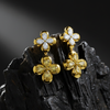 Celebrate moments of grandeur with these drop earrings featuring white and yellow diamond flowers resting on a dark, jagged rock.