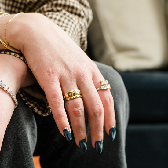 Yellow gold geometric stackable ring worn on a model's hand.