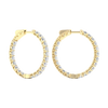A profile view of 14K yellow gold huggie hoop earrings, showing a continuous circle of brilliant, round-cut diamonds on the outer circumference.