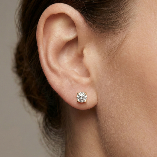 Front view of white gold round solitaire diamond stud earrings featuring brilliant-cut diamonds secured in a classic four-prong setting on ear.