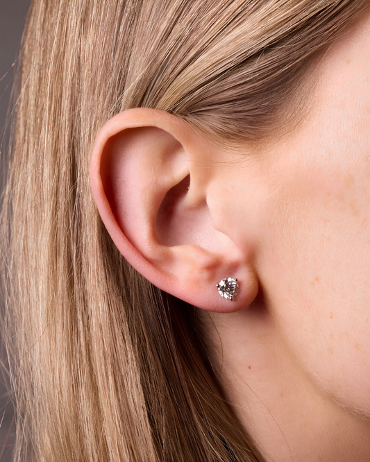Amorati Bold 1.0 cttw Martini-set stud earring on model view of a 10K white gold three-prong .24 ct total weight diamond stud earrings, shown on the left ear.