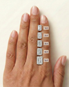 On-hand comparison of emerald cut diamonds from 1 carat, 2 carat, 3 carat, 4 carat, 5 carat.