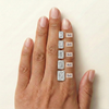 On-hand comparison of emerald cut diamonds from 1 carat, 2 carat, 3 carat, 4 carat, 5 carat.