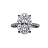 Top-down view of a classic white gold or platinum engagement ring featuring a large brilliant oval-cut center diamond on a sparkling micro-pavé diamond band.