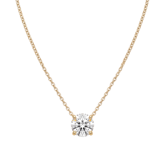 Product shot of a delicate yellow-tone chain necklace featuring a brilliant round-cut clear gemstone in a four-prong setting, displayed against a white background.