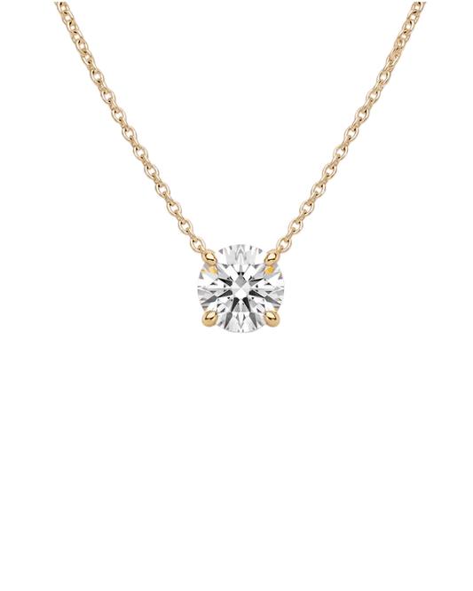 Product shot of a delicate yellow-tone chain necklace featuring a brilliant round-cut clear gemstone in a four-prong setting, displayed against a white background.