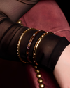 A luminous, high-polish 14K yellow gold bangle from the Amorati Fourteen Collection, featuring delicately scattered star-shaped insets set with shimmering round lab-grown diamonds, gracefully styled on a model’s wrist.