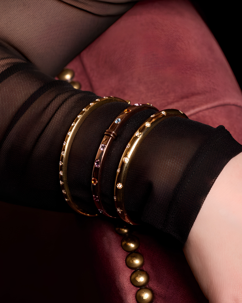 A bold, high-polish 14k yellow gold statement bangle by Amorati featuring scattered star and geometric insets with shimmering round-cut lab-grown diamonds, gracefully styled on a model’s wrist. Amorati’s signature F O U R T E E N T H Collection