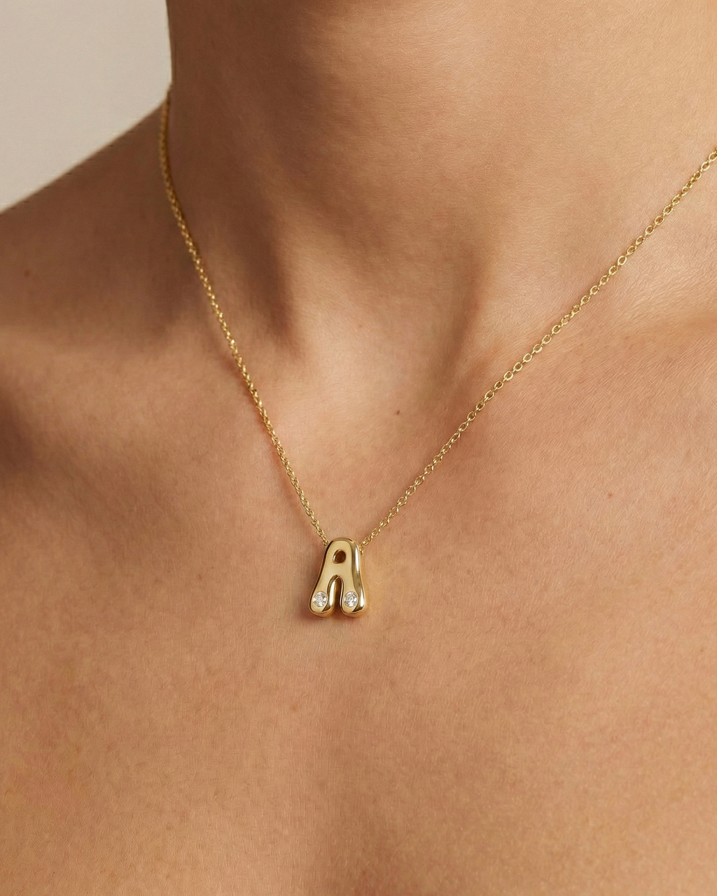 A high-polish 14k yellow gold initial pendant by Amorati featuring star and geometric insets with shimmering round-cut lab-grown diamonds. Amorati’s signature F O U R T E E N T H Collection on figure.