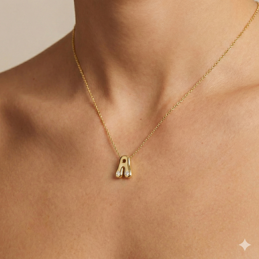 A high-polish 14k yellow gold initial pendant by Amorati featuring star and geometric insets with shimmering round-cut lab-grown diamonds. Amorati’s signature F O U R T E E N T H Collection on figure.