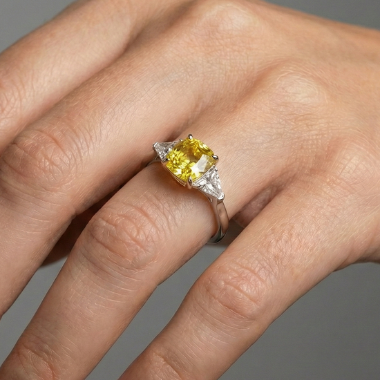 On hand view of the 4.16 Cttw Soleil Cushion Canary Trilogy Diamond Ring with 3.50ct IGI Certified Center Yellow Canary Cushion Stone and an additional .66 cttw Trillion Side Stones