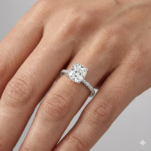 Elongated Cushion cut diamond engagement ring in 14k white gold with a pavé diamond band and cathedral setting on a hand.