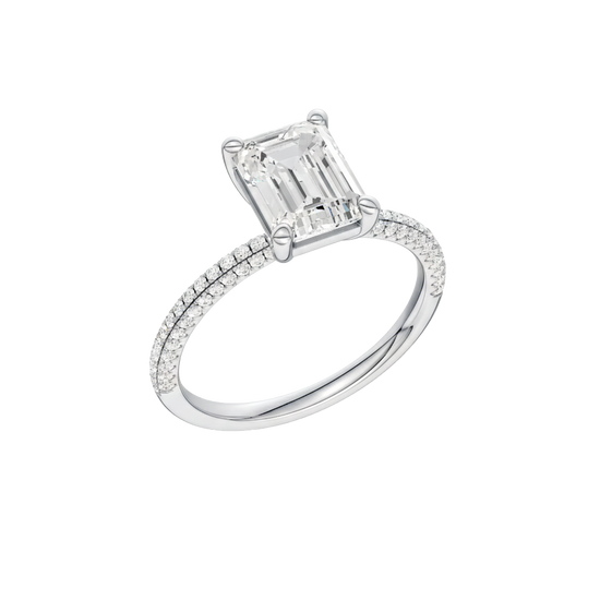 A three-quarter view of the Emerald cut diamond engagement ring in 14k white gold with a pavé diamond band and cathedral setting