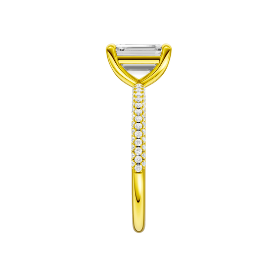 A side view of the Emerald cut diamond engagement ring in 14k yellow gold with a pavé diamond band and cathedral setting
