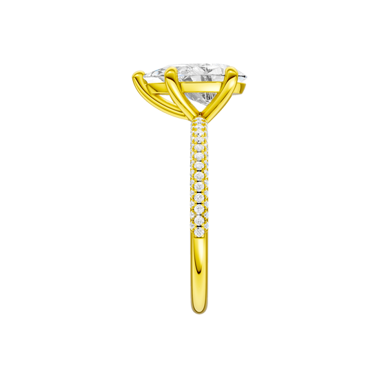 A side view of the Pear cut diamond engagement ring in 14k yellow gold with a pavé diamond band and cathedral setting