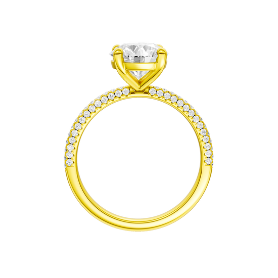 A profile view of the Round cut diamond engagement ring in 14k yellow gold with a pavé diamond band and cathedral setting