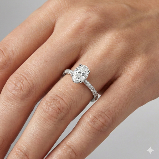 Oval cut diamond engagement ring in 14k white gold with a pavé diamond band and cathedral setting on a hand