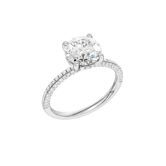 A three-quarter view of the Round cut diamond engagement ring in platinum with a pavé diamond band and cathedral setting