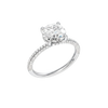 A three-quarter view of the Round cut diamond engagement ring in platinum with a pavé diamond band and cathedral setting
