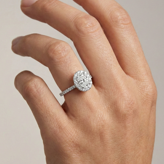 Elongated cushion cut diamond engagement ring in 14k white gold with a pavé diamond band and solitaire setting on a hand