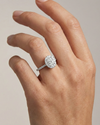 Elongated cushion cut diamond engagement ring in 14k white gold with a pavé diamond band and solitaire setting on a hand