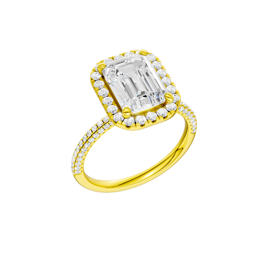 A three-quarter view of the Emerald cut diamond engagement ring in 14k yellow gold with a pavé diamond band and solitaire setting