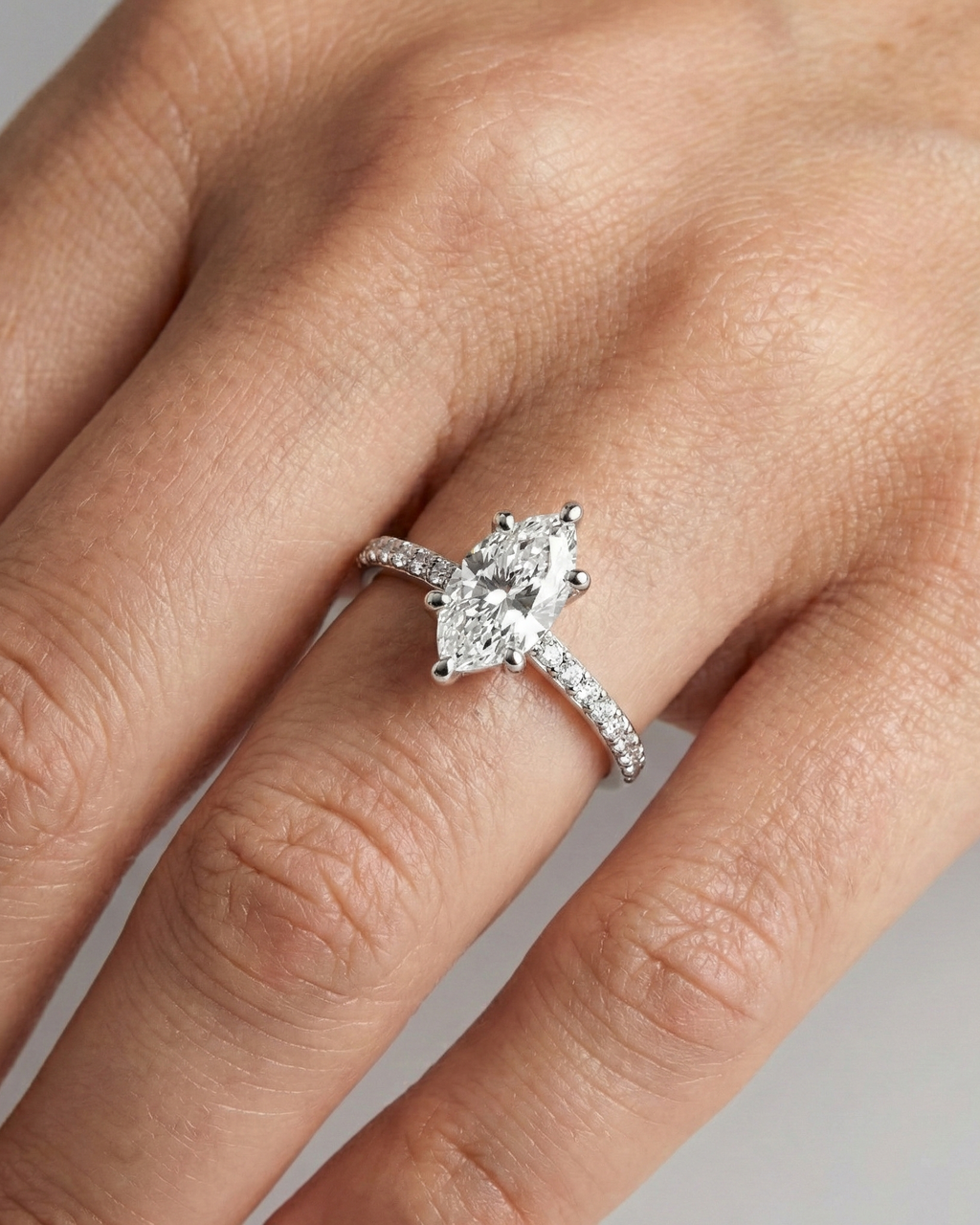 Marquise cut diamond engagement ring in 14k white gold with a prong diamond band and cathedral setting on a hand