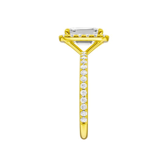A side view of the Emerald cut diamond engagement ring in 14k yellow gold with a prong diamond band and cathedral setting