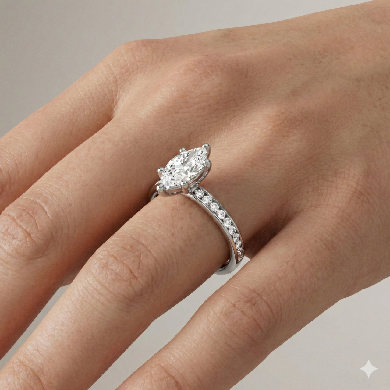 Marquise cut diamond engagement ring in 14k white gold with a diamond channel band and cathedral setting on a hand