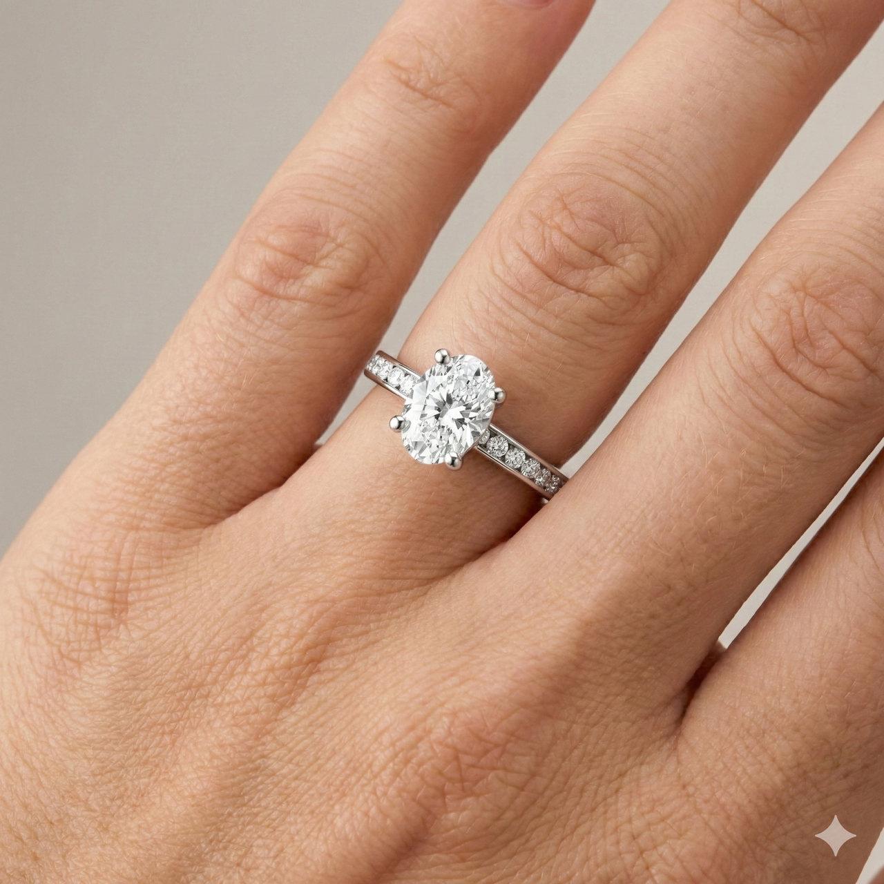 Oval cut diamond engagement ring in 14k white gold with a diamond channel band and cathedral setting on a hand