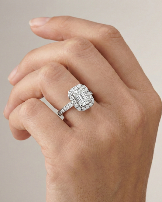Emerald cut diamond engagement ring in 14k white gold with a diamond channel band and cathedral setting on a hand
