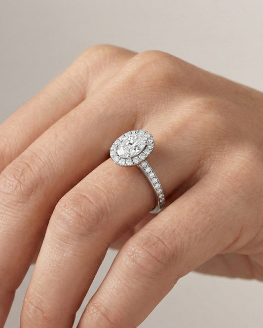 Oval cut diamond engagement ring in 14k white gold with a diamond channel band and cathedral setting on a hand