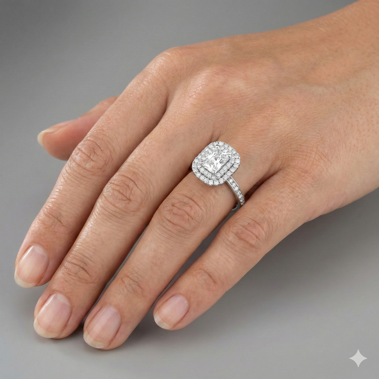 Radiant cut diamond engagement ring in 14k white gold with a diamond channel band and cathedral setting on a hand