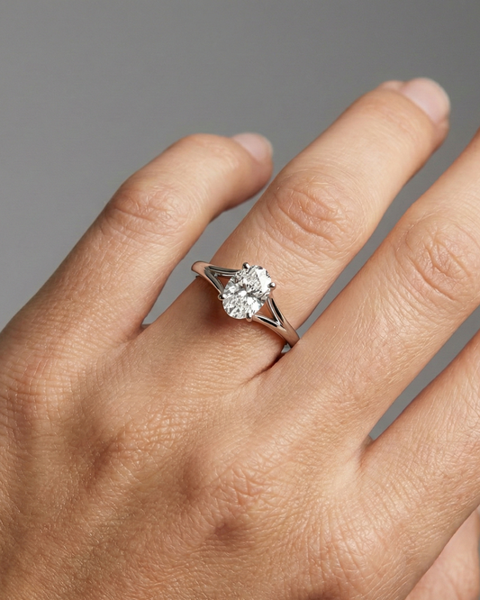 Oval cut diamond engagement ring in 14k white gold with a plain band and split setting on a hand