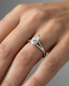 Pear cut diamond engagement ring in 14k white gold with a plain band and split setting on a hand