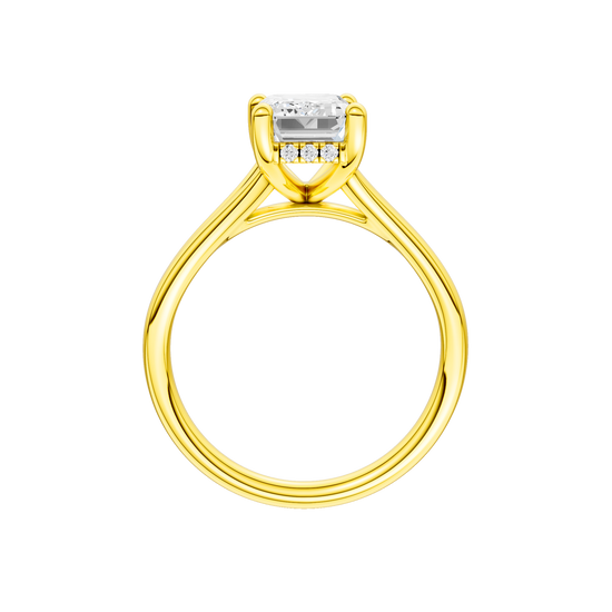 A profile view of the Emerald cut diamond engagement ring in 14k yellow gold with a plain band and hidden halo setting