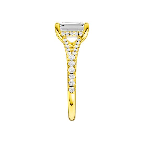 A side view of the Emerald cut diamond engagement ring in 14k yellow gold with a prong diamond band and hidden halo setting